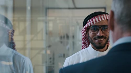 Businessman Having Conversation with Arab Colleague at Office