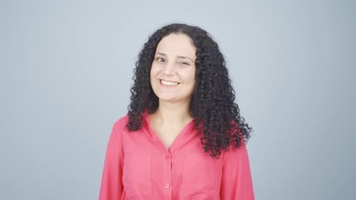 Smiling Woman Winks on Gray Background