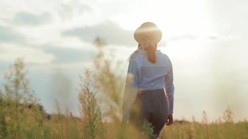 At Sunlight Shot Back Woman with Hat at Walking on a Field Expression Warm Nature Holidays Vacations