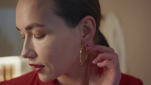 Woman Puts On Gold Hoop Earrings