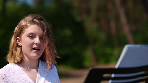 Young Woman Singing Outdoors with Music Stand