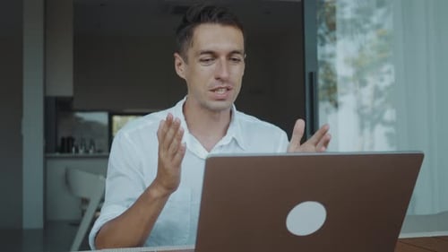 Remote Worker Smiling and Talking on Laptop During Online Meeting at Home Office Remote