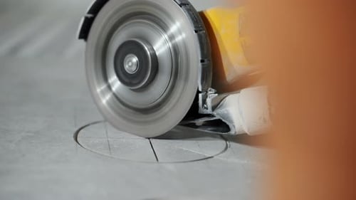 Closeup of a Construction Worker Cutting a Tile Surface Using a Rotary Power Tool Precision Cutting