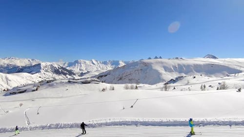 Droneshot over a skilift with skiers and snowboarders in a snowy winter mountain landscape, in the L