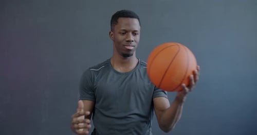 Young Man Spins Basketball on Hand