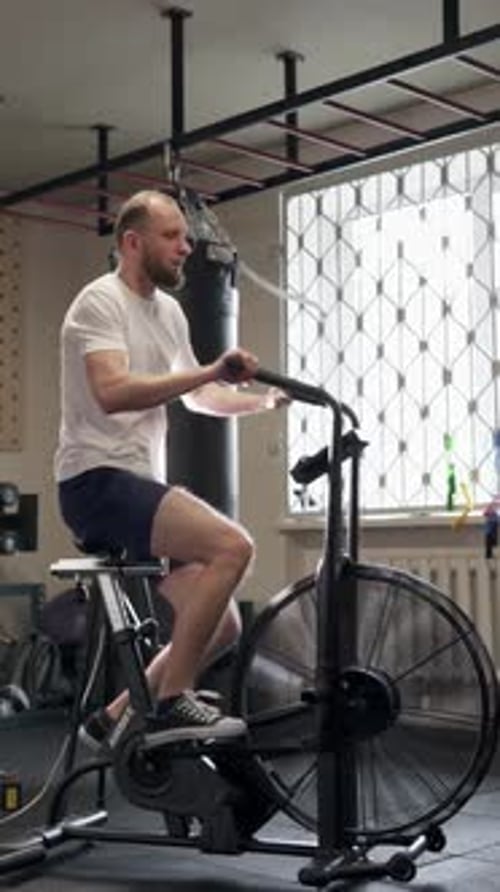 Man Working out on Exercise Bike in Gym