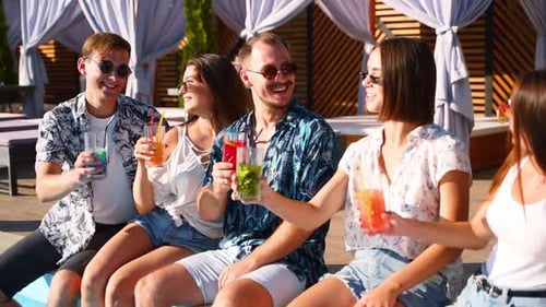 Friends Toasting Drinks By the Poolside in Summertime