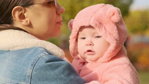 Portrait of a Little Newborn Girl with Her Mother in an Autumn Park