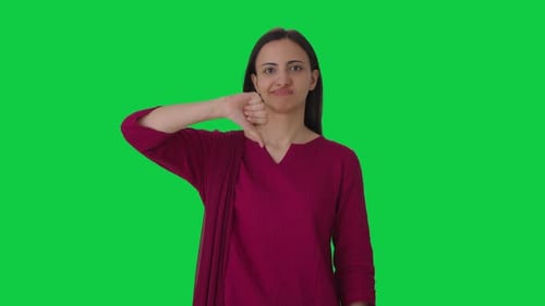 Upset Indian female teacher showing thumbs down Green screen