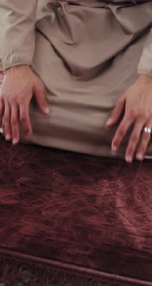 Man Kneeling on Prayer Rug Inside