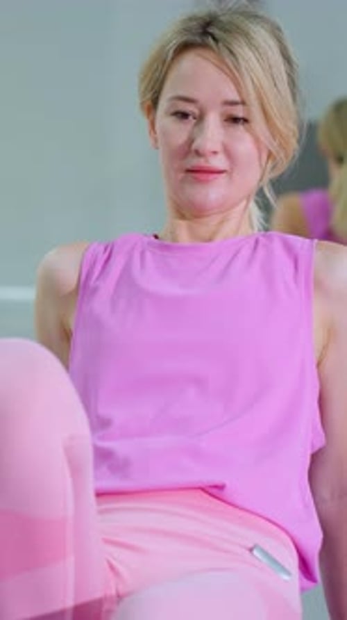Woman Exercising on Yoga Mat with Mirror Reflection in Gym