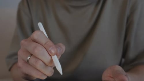 Hand using stylus on digital tablet for design