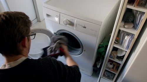 Man starts Loading Dirty Clothes In Washing at home top view Wide angle Unrecognizable