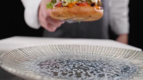 Chef Places Finished Sandwich on Plate Close Up