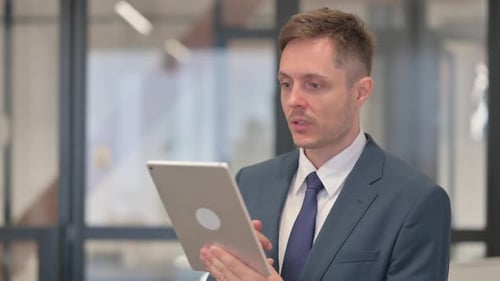 Man in Suit Using Tablet for Video Call