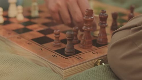 Unrecognizable Man Making Checkmate during Chess Game