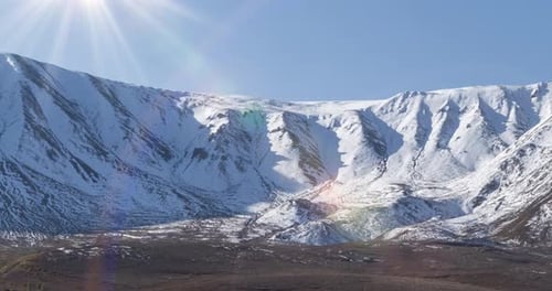 Timelapse of Sun Movement on Crystal Clear Sky Over Snow Mountain Top Yellow Grass at Autumn Meadow