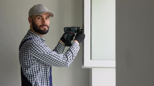 A Repairman in Uniform Fixing Windows in New Apartment