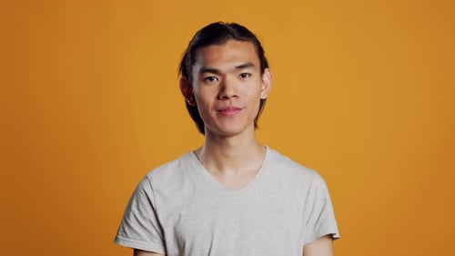 Cheerful Smiling Guy Posing on Orange Background