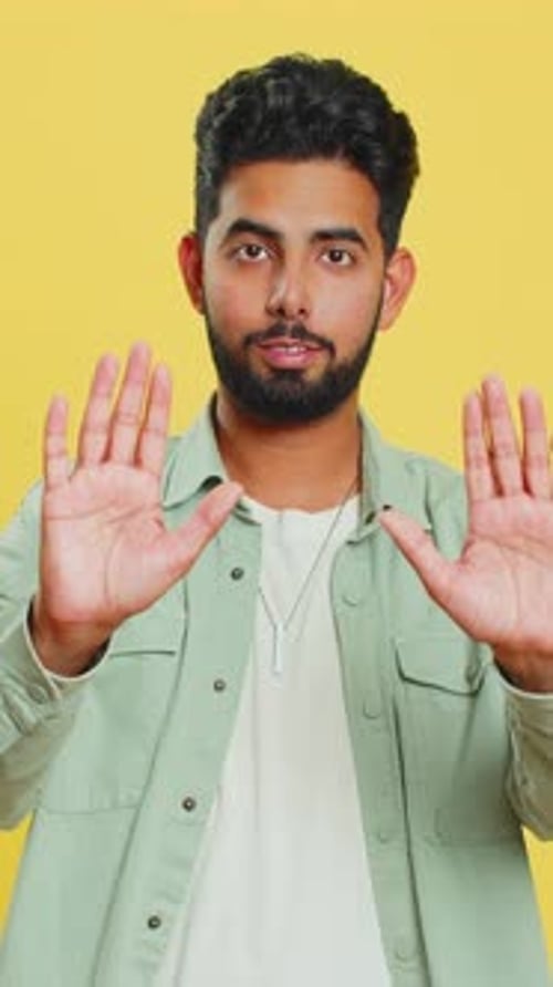 Young Man Gesturing Size with Hands on Yellow Background