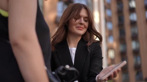 Woman Holds Phone and Stands with Friend