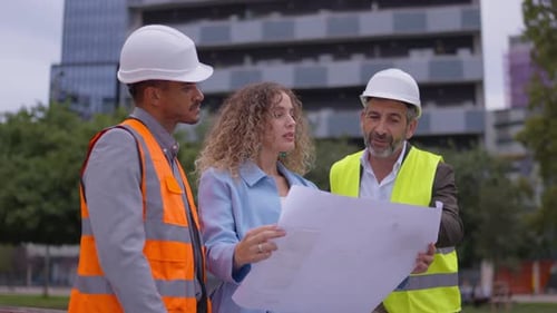 Architect Team Reviewing Blueprints at Urban Construction Site