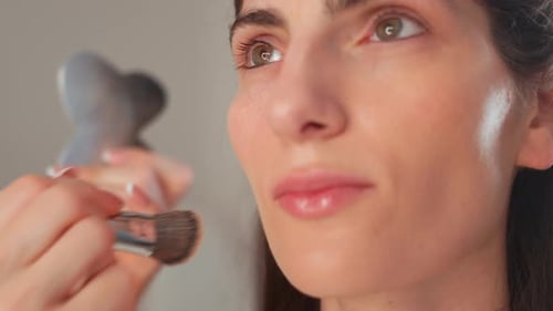 Makeup Artist Applying Foundation on Woman's Face in Studio