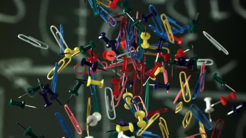 Colorful Paperclips and Tacks Falling in Slow Motion