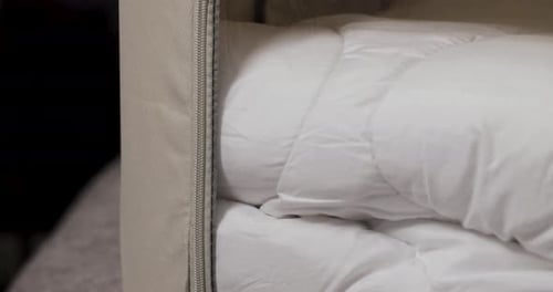 La
literie est soigneusement rangée dans une boîte de rangement fermée. Prise de vue inclinée en 4K