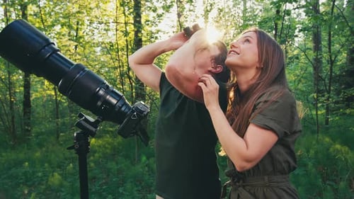 Observation des
oiseaux dans le parc. Couple observe les oiseaux avec des jumelles et un appareil photo avec téléobjectif. Oiseau amateur