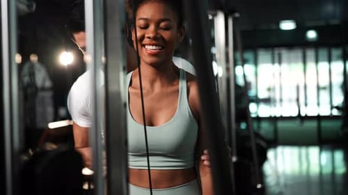 Trainer coaching male training sportswoman doing bodybuilding in the fitness gym