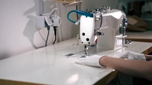 Professionelle chemische Reinigung, junges Mädchen, säumt einen Patch auf einem Pullover mit einer Nähmaschine
