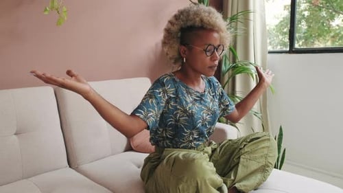 Woman Meditating on Couch in Living Room
