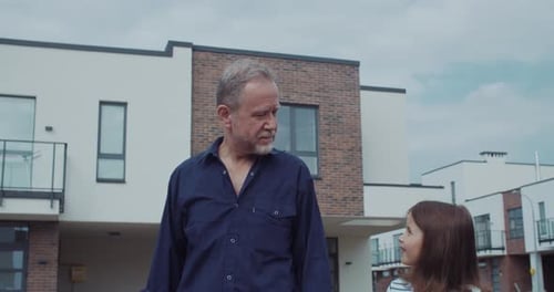 Grandfather and Granddaughter Walking in Suburban Neighborhood