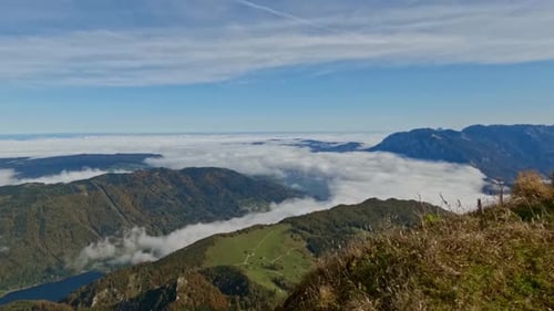 Ein atemberaubender Zeitraffer einer Berglandschaft mit einer dicken Wolkenschicht, die das Tal bedeckt