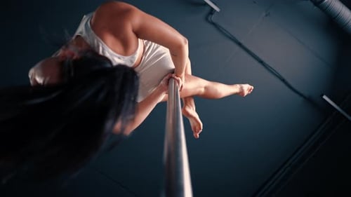 Strong Woman Performing Advanced Pole Fitness Routine