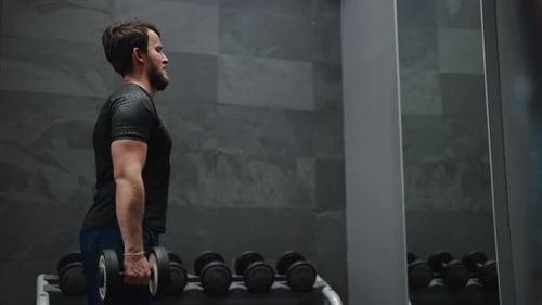 Male perform active lifestyle at gym, do standing dumbbell biceps curl