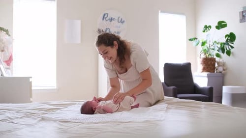 Mother with Infant Baby on Bed at Home