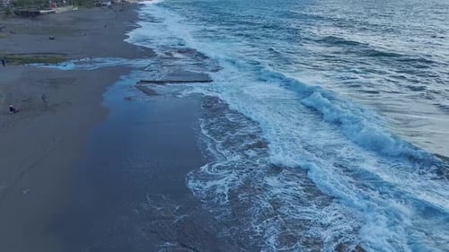 Aerial Video Rolling Stormy Waves Create Stunning Foam Patterns on the Beach Below