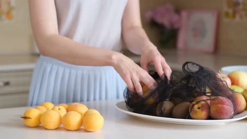 Una mujer morena pone fruta en una bolsa ecológica