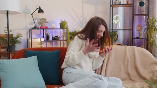 Woman Reacts with Joy While Using Smartphone