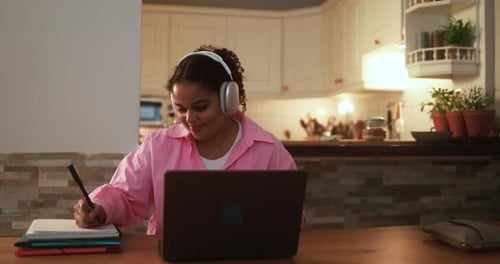 African girl using laptop computer at home while working on school project