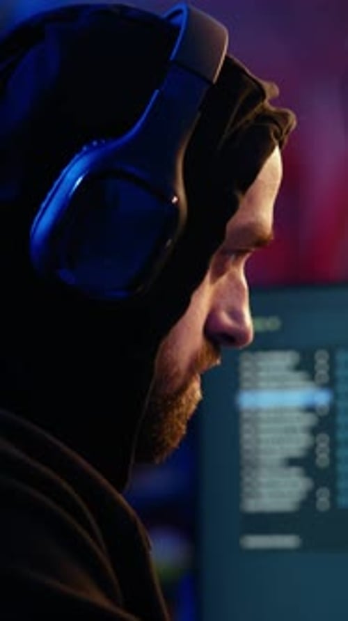 Vertical Video Anxious Hacker Hiding in Bunker Removing Headphones to Hear Suspicious Sounds