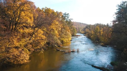 Fly over the rapid river. Quick flow of water among the bright banks.