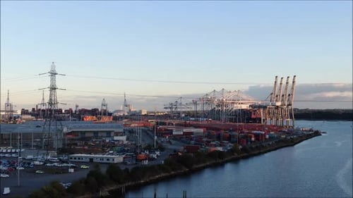 Foto aérea de drone do porto de Southampton. Terminal de contêineres movimentado com navios e guindastes.
UMA