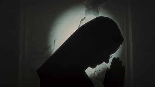Silhouette of Nun Praying to Lord Side View