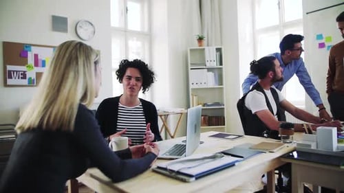 Young business team collaborating with laptop in a modern open office space