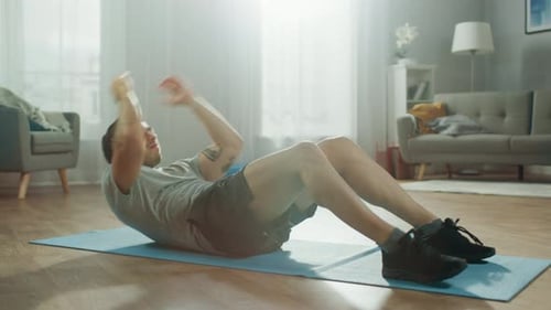 Man doing sit ups on exercise mat indoors