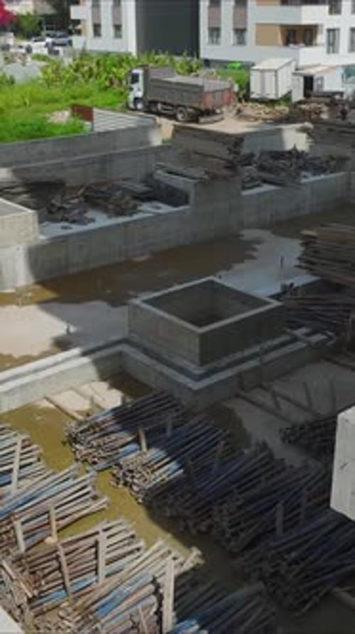 Vertical Aerial Shot of High Rise Under Construction in Dense Residential Area