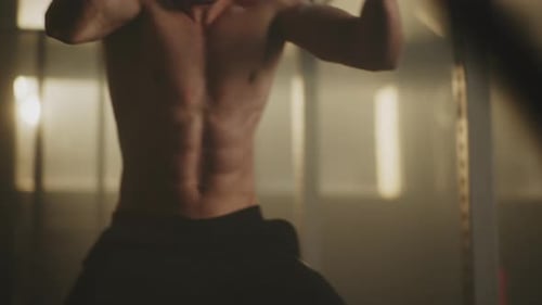Fit Man Exercising with Battle Ropes at the Gym
